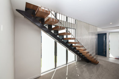 Modelo de escalera recta moderna de tamaño medio sin contrahuella con escalones de madera y barandilla de metal