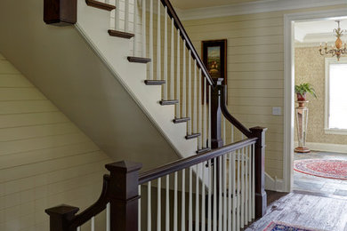 Diseño de escalera curva clásica grande con escalones de madera, contrahuellas de madera y barandilla de madera