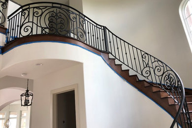 Design ideas for a large curved metal railing staircase in Houston.