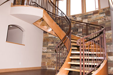 Huge trendy wooden curved open staircase photo in Denver