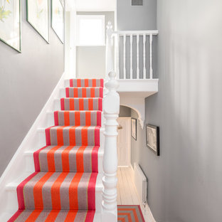 Scandinavian painted wood u-shaped wood railing staircase in London with painted wood risers.