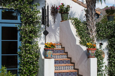 Photo of a large mediterranean staircase in Houston with tiled risers and terracotta treads.