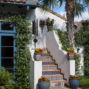 Große Mediterrane Treppe mit gefliesten Setzstufen und Terrakotta-Treppenstufen in Houston