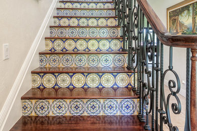Diseño de escalera recta mediterránea grande con escalones de madera y contrahuellas con baldosas y/o azulejos