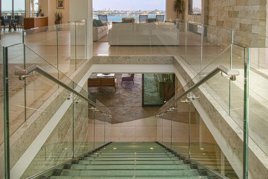 Immagine di una grande scala a rampa dritta design con pedata in vetro, nessuna alzata e parapetto in vetro