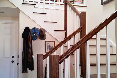 Photo of a beach style wood u-shaped wood railing staircase with painted wood risers.