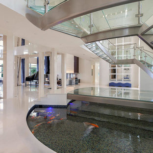 Immagine di un'ampia scala curva design con pedata in vetro