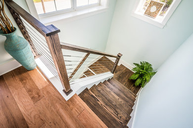 Imagen de escalera en U marinera de tamaño medio con escalones de madera, contrahuellas de madera pintada y barandilla de varios materiales