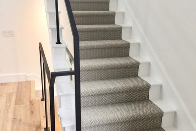 Inspiration for a mid-sized transitional carpeted straight metal railing staircase remodel in Orange County with wooden risers