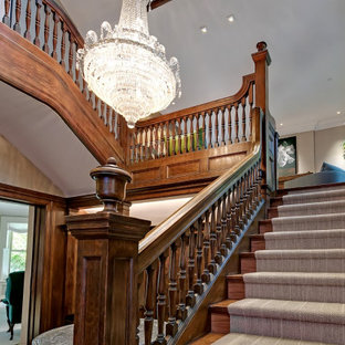 Exemple d'un très grand escalier victorien en U avec des marches en bois, des contremarches en bois et un garde-corps en bois.