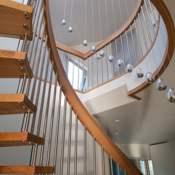 Beautiful curved stairs with drop globe lights