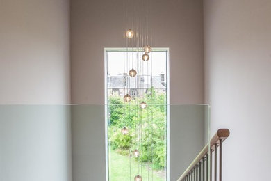 Design ideas for a medium sized contemporary glass floating metal railing staircase in Edinburgh.