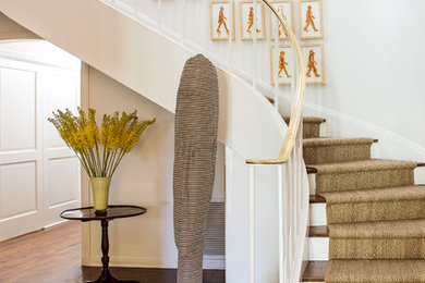 Design ideas for a large classic wood curved staircase in Los Angeles with painted wood risers and feature lighting.