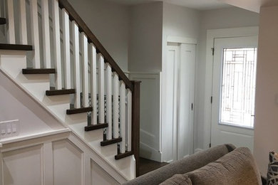 Ejemplo de escalera recta tradicional de tamaño medio con escalones de madera y barandilla de madera