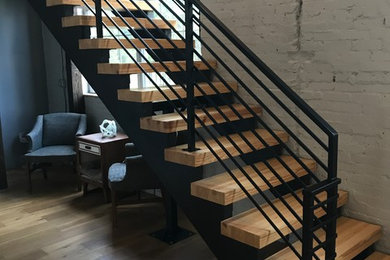 Diseño de escalera en L moderna grande con escalones de madera, contrahuellas de madera pintada y barandilla de metal