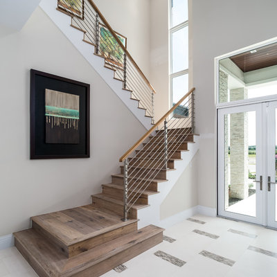 Inspiration for a large transitional wooden u-shaped cable railing staircase remodel in Miami with wooden risers
