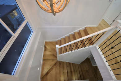 Cette photo montre un escalier tendance avec des marches en bois et un garde-corps en bois.