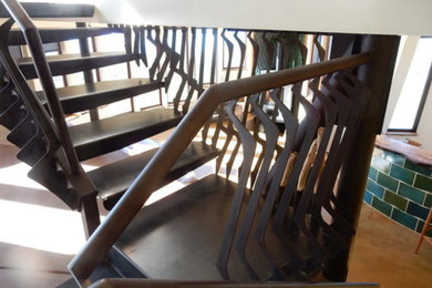Пример оригинального дизайна: изогнутая лестница среднего размера в стиле фьюжн с металлическими ступенями без подступенок