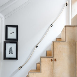 Ejemplo de escalera bohemia, pequeña, con escalones de madera, contrahuellas de madera y barandilla de varios materiales