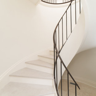 Immagine di una grande scala curva mediterranea con pedata in pietra calcarea e alzata in legno