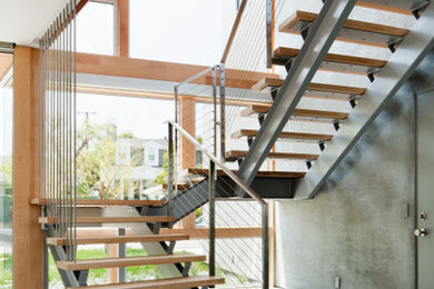 Trendy wooden floating open staircase photo in Los Angeles