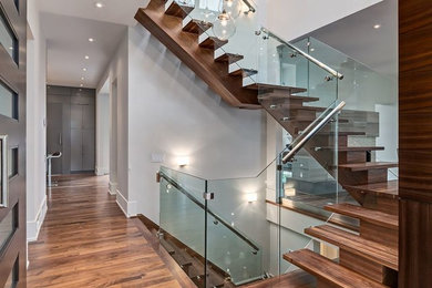 Foto de escalera en U actual de tamaño medio con escalones de madera, contrahuellas de madera y barandilla de vidrio