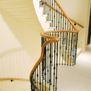 Immagine di un'ampia scala curva design con pedata in cemento e alzata in cemento