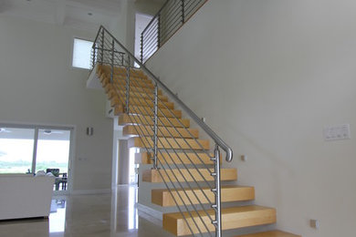 Foto de escalera suspendida contemporánea de tamaño medio sin contrahuella con escalones de madera y barandilla de metal