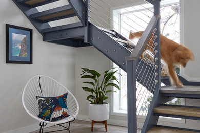 Example of a beach style wooden u-shaped open and cable railing staircase design in Portland Maine