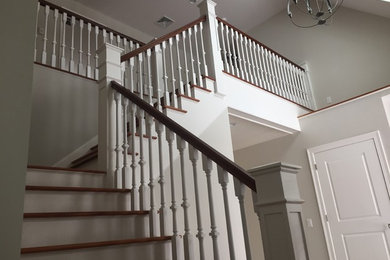 Inspiration for a mid-sized timeless wooden l-shaped staircase remodel in Other with painted risers