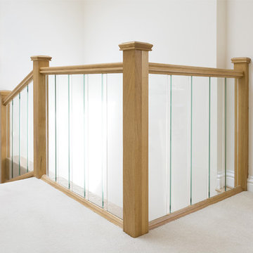 Carpeted Staircase featuring Glass Balustrades