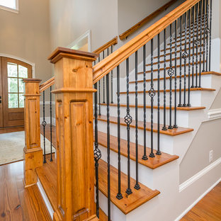 Esempio di un'ampia scala a rampa dritta stile americano con pedata in legno e alzata in legno verniciato