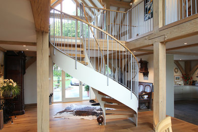 Photo of a farmhouse wood spiral staircase in Other with open risers.