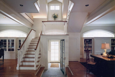 Idée de décoration pour un grand escalier peint tradition en L avec des marches en bois, un garde-corps en bois et éclairage.