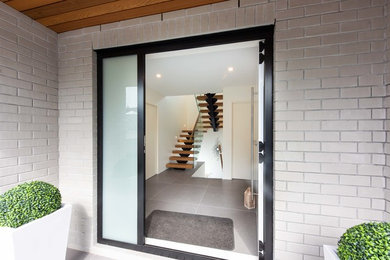 Foto de escalera suspendida moderna grande sin contrahuella con escalones de madera y barandilla de vidrio