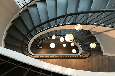 Huge trendy painted spiral metal railing staircase photo in Chicago with painted risers