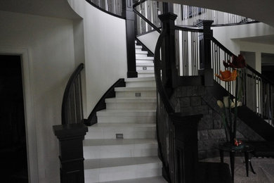 Diseño de escalera curva tradicional renovada de tamaño medio con barandilla de madera