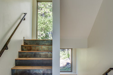 Large minimalist wooden u-shaped staircase photo in Seattle with metal risers