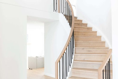 Inspiration pour un grand escalier hélicoïdal traditionnel avec des marches en bois, des contremarches en bois et un garde-corps en matériaux mixtes.