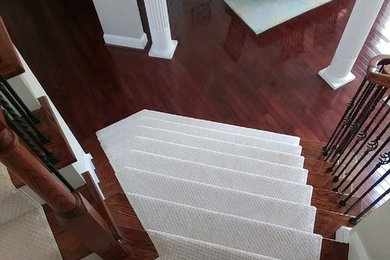 Diseño de escalera en L tradicional de tamaño medio con barandilla de metal, escalones de madera y contrahuellas de madera