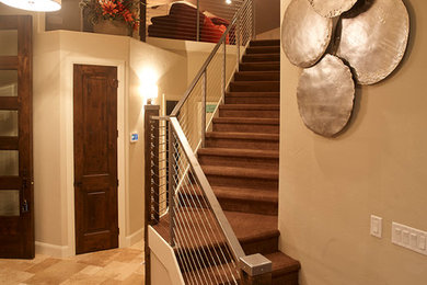 デンバーにある広い地中海スタイルのおしゃれな直階段 (カーペット張りの蹴込み板) の写真