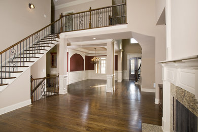 Diseño de escalera recta clásica grande con escalones de madera pintada, contrahuellas de madera y barandilla de varios materiales