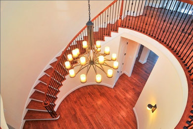 Example of a large arts and crafts wooden curved wood railing staircase design in Baltimore with painted risers