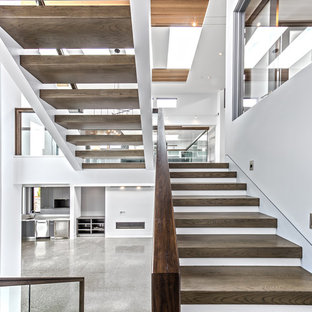 Large trendy wooden u-shaped open and glass railing staircase photo in Seattle