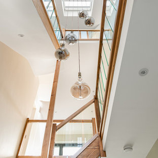 Esempio di una grande scala a "L" design con parapetto in legno