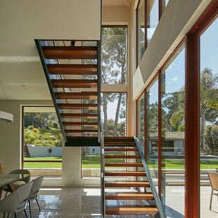 Example of a trendy wooden u-shaped open and glass railing staircase design in Los Angeles