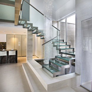 Inspiration pour un grand escalier sans contremarche design en U avec des marches en verre.