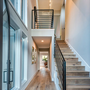 Diseño de escalera recta, moderna, pequeña, con escalones de madera, contrahuellas de madera y barandilla de metal