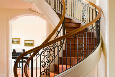 Classic wood curved staircase in Denver with wood risers.