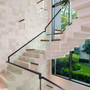 Ejemplo de escalera suspendida, contemporánea, grande, con escalones con baldosas, contrahuellas con baldosas y/o azulejos y barandilla de varios materiales